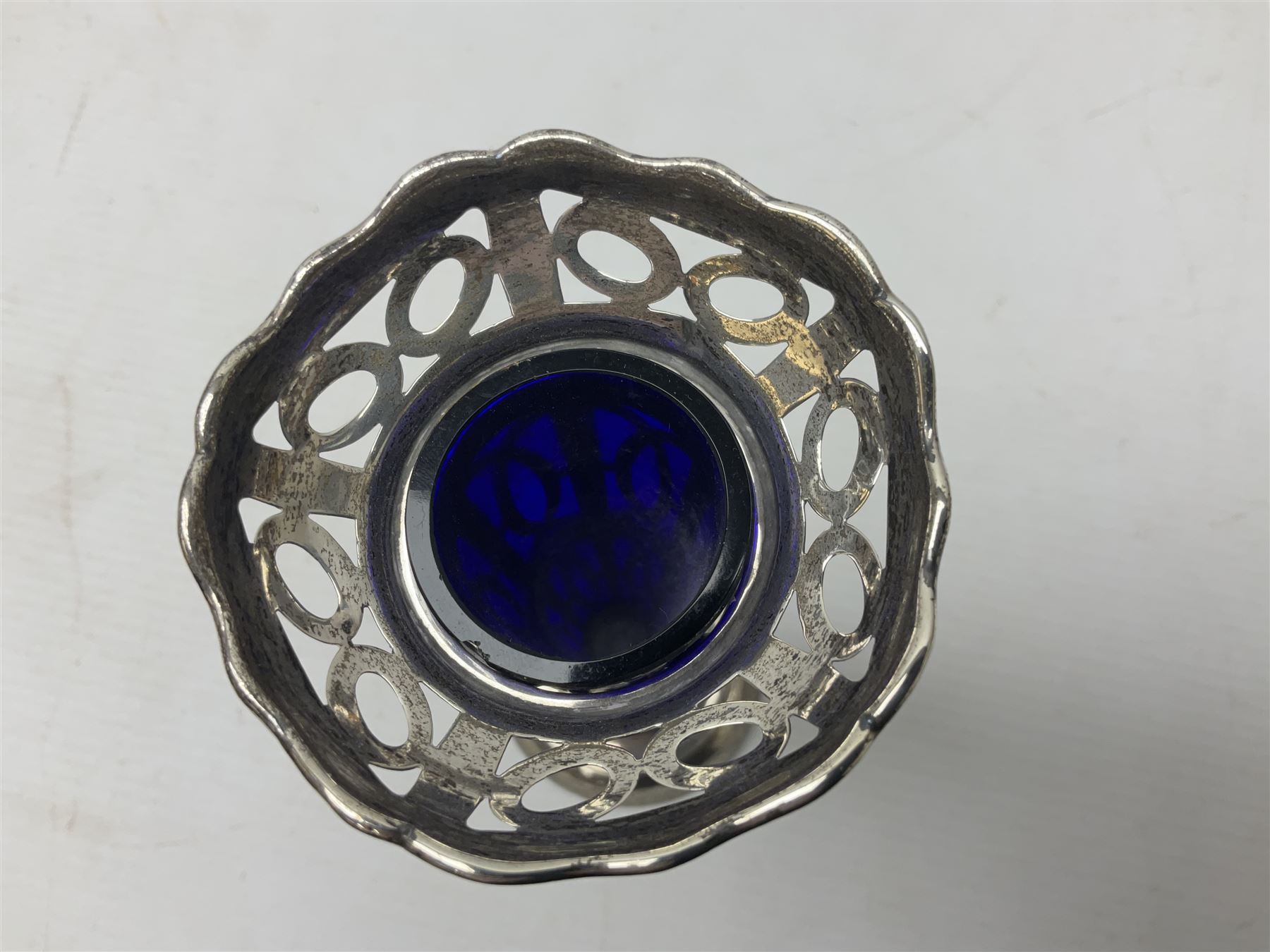 20th century silver specimen vase, of pierced trumpet form with flared rim, filled base, and blue glass liner, hallmarked Birmingham 