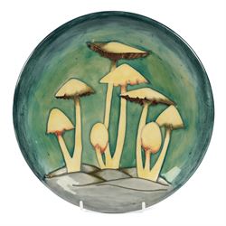 Moorcroft Fairy Ring plate, 1990, decorated with mushrooms upon a green ground, with paint...