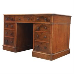 Victorian mahogany writing desk, featuring inset tooled red leather top, raised on two pedestals, nine drawers with figured veneer fronts