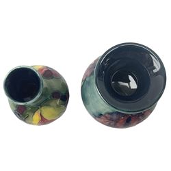 Moorcroft vase, decorated in the Leaf and Berries pattern upon a tonal green ground, together with a further Moorcroft vase, of squat baluster form, decorated in the Iris pattern upon a tonal green ground, each with impressed marks beneath, each H9cm. 