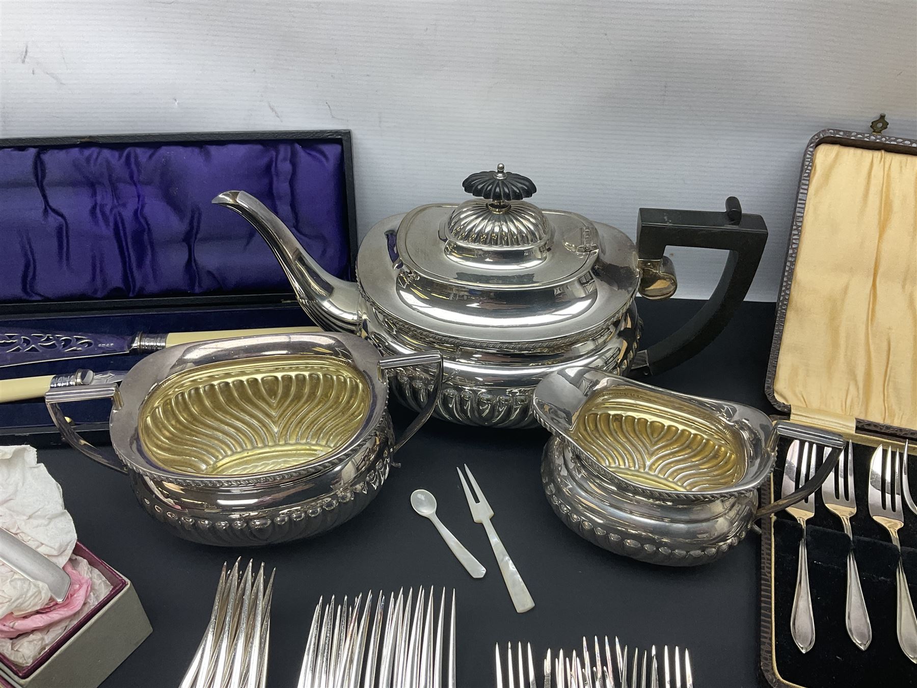 Mother of Pearl handled cutlery, with silver ferrules, comprising six fish knives and forks and six fruit knives and forks, the ferrules hallmarked Yates Brothers, Sheffield 1905, together with silver plated Edwardian three piece tea service and other flatware 