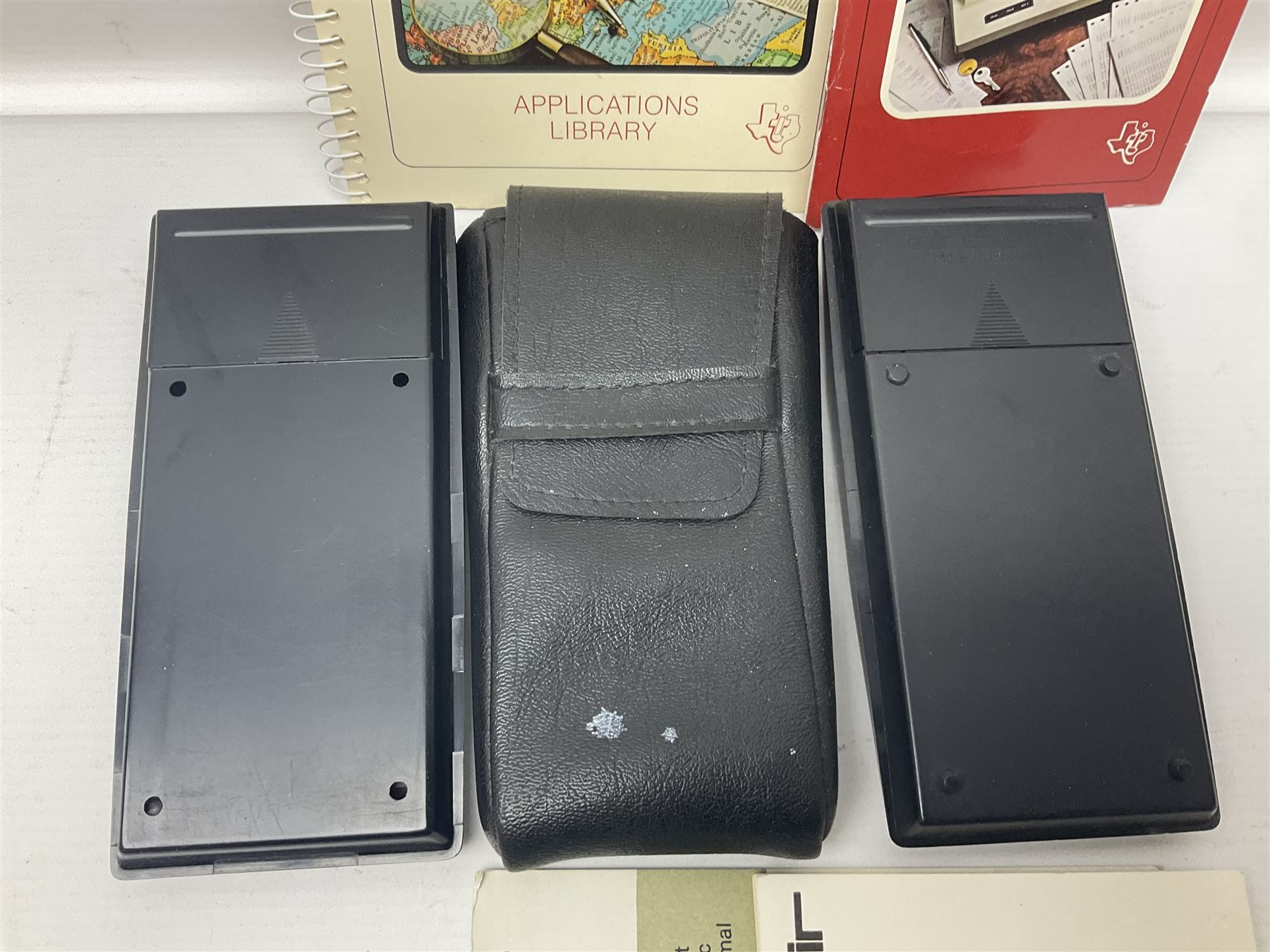 Four 1970s Sinclair electronic calculators - Cambridge in hard case with booklet; Scientific Programmable with Program Library and booklet; Scientific in hard case; and Oxford 300 in soft case with booklet; together with Texas PC-100 SR56 programmable slide-rule calculator on base station with readout, two booklets, keys and cover, serial no.9103093