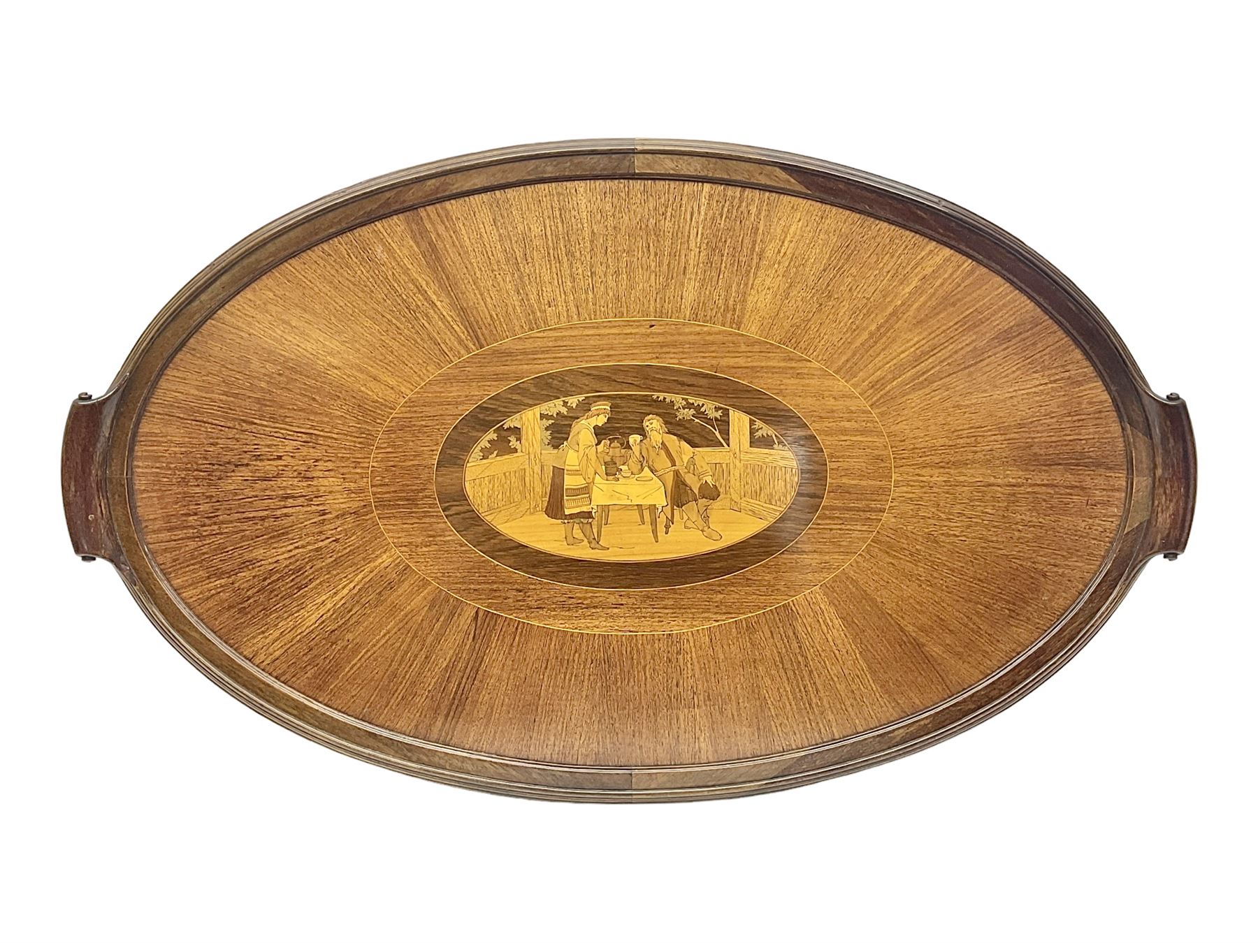 Late 19th/early 20th century mahogany and marquetry inlaid tray, of oval form with twin scrolled handles and moulded border, the central panel inlaid with figures seated at a table drinking tea, L99cm