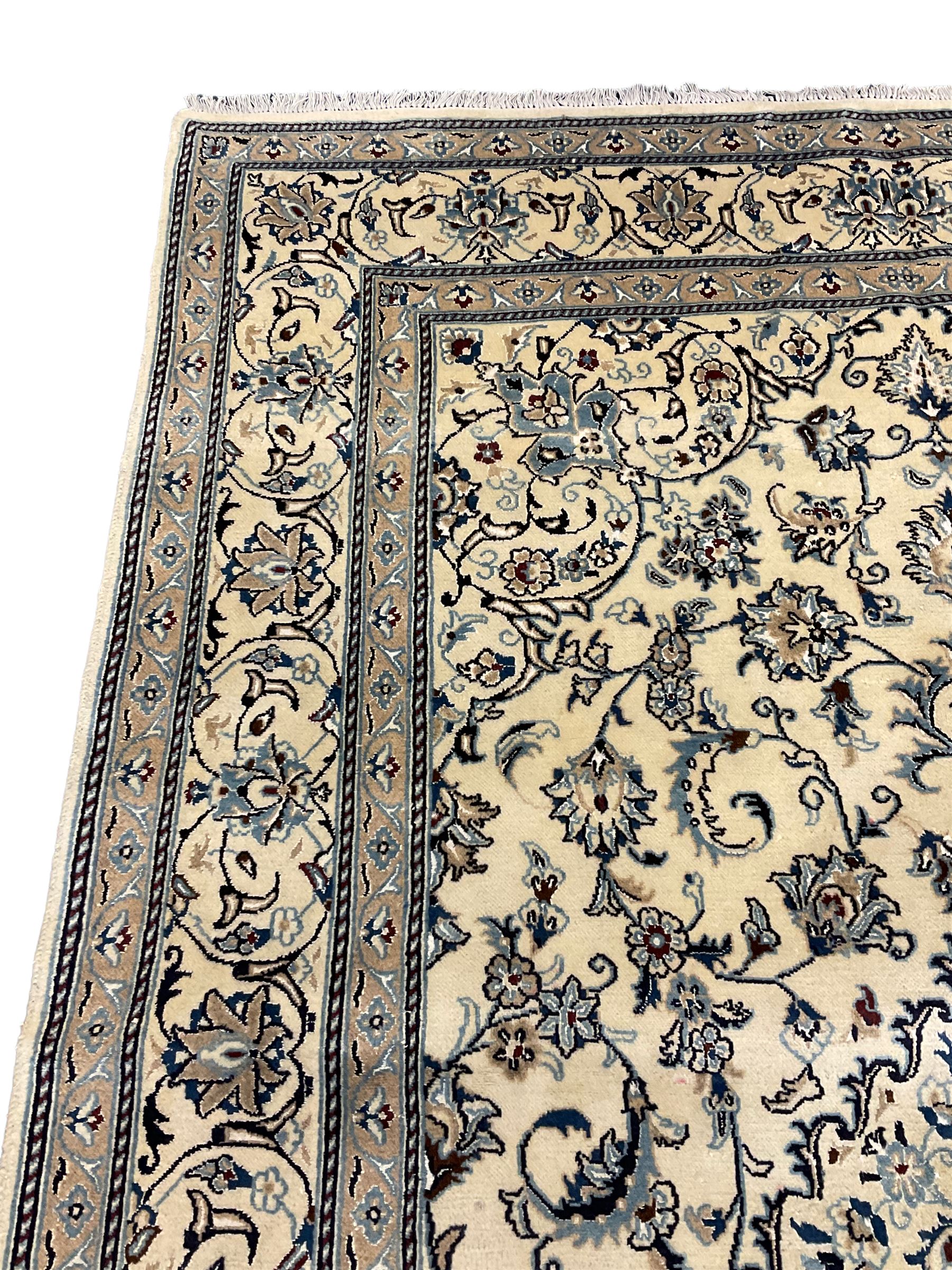 Central Persian Nain rug, wool with silk inlay, ivory ground decorated with scrolling and interlaced branch with stylised plant motifs, central floral medallion, triple band border with repeating design