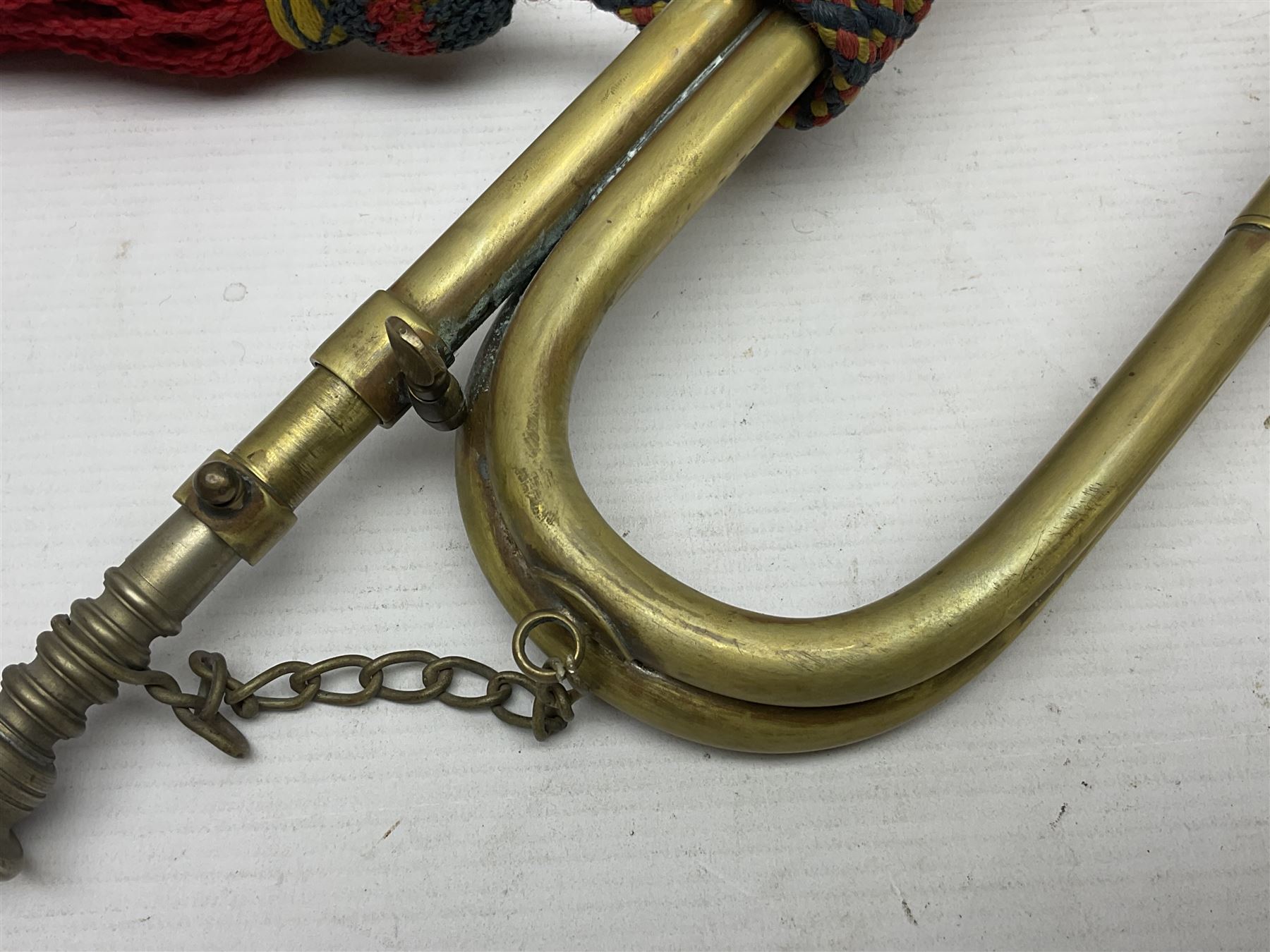 Two military brass bugles by Mayers and Harrison Ltd. Manchester each with crows foot mark and dated 1966; both with multi-coloured cord and tassels, longest 52.5cm (2)