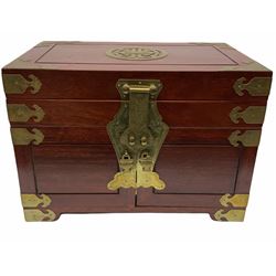 Chinese hardwood jewellery box mounted with engraved brass fixtures, the two exterior doors revealing three drawers below the hinged upper lid, lined with red material decorated with floral sprays, H25cm, W36cm, D23cm