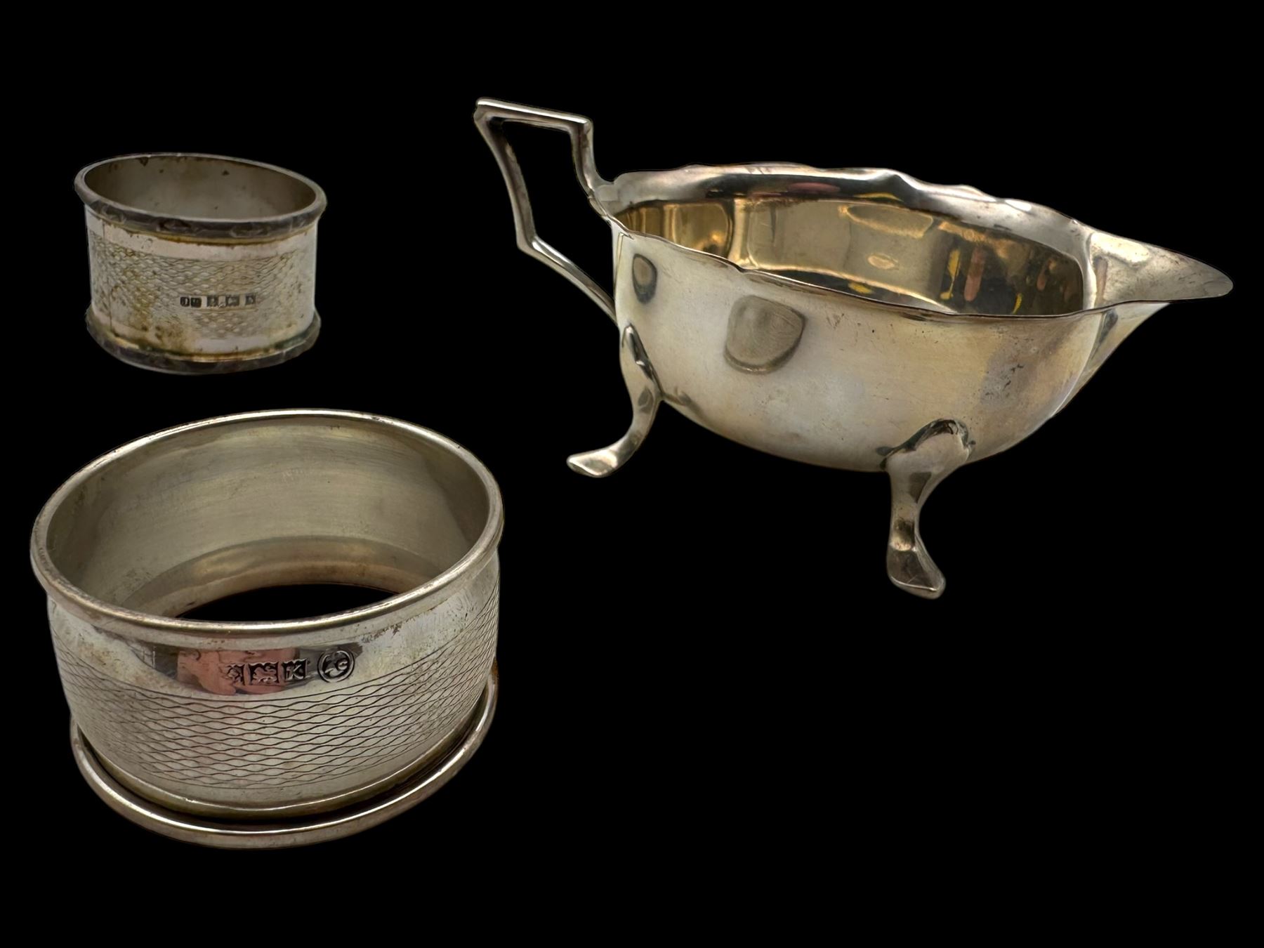 Silver cream jug and two napkin rings, all hallmarked 