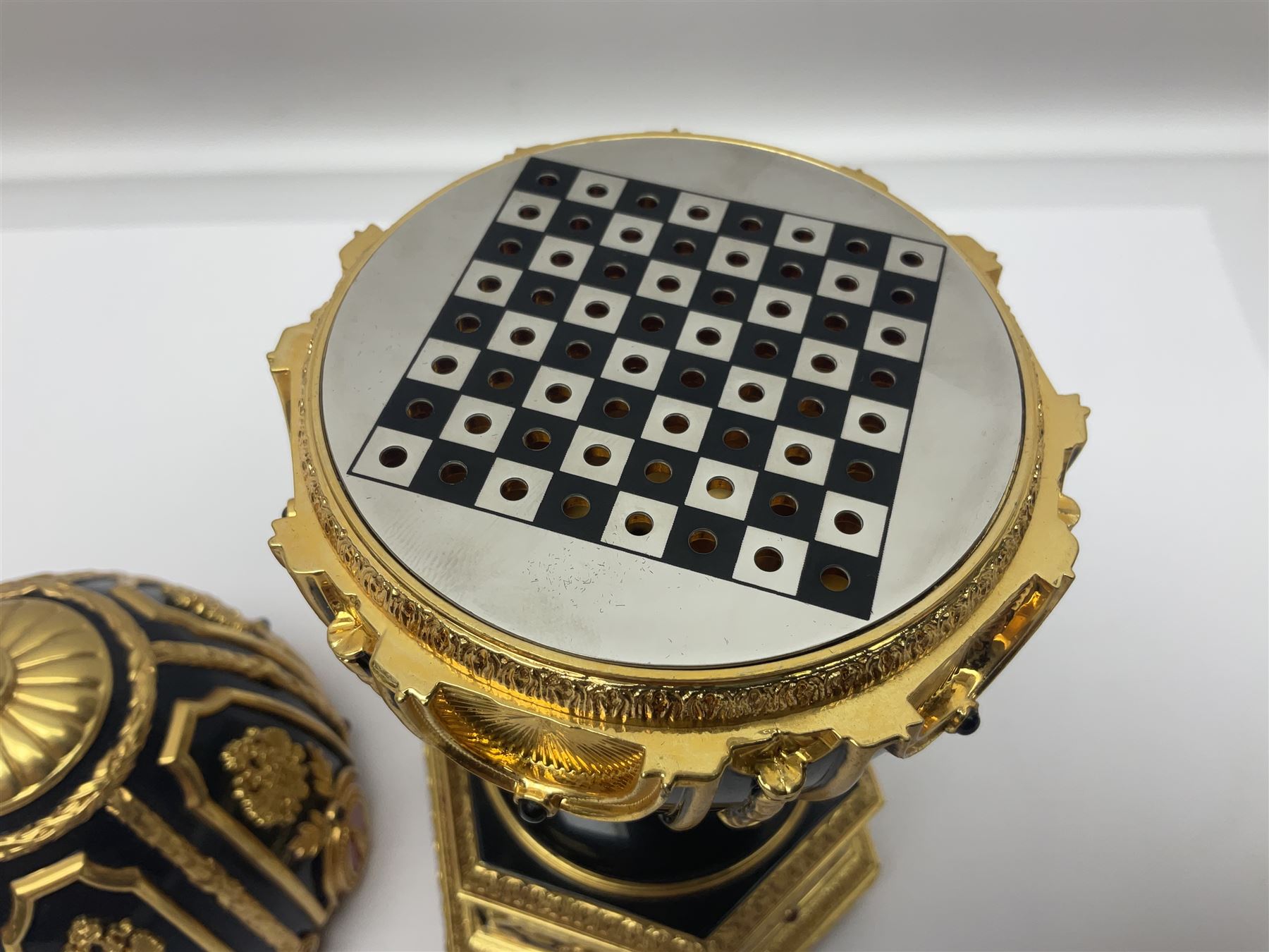 Franklin Mint House of Faberge; The Imperial Jeweled Egg Chess set, the egg opening to reveal a chess board, with a draw to the hexagonal base holding the miniature chess pieces, H23cm 