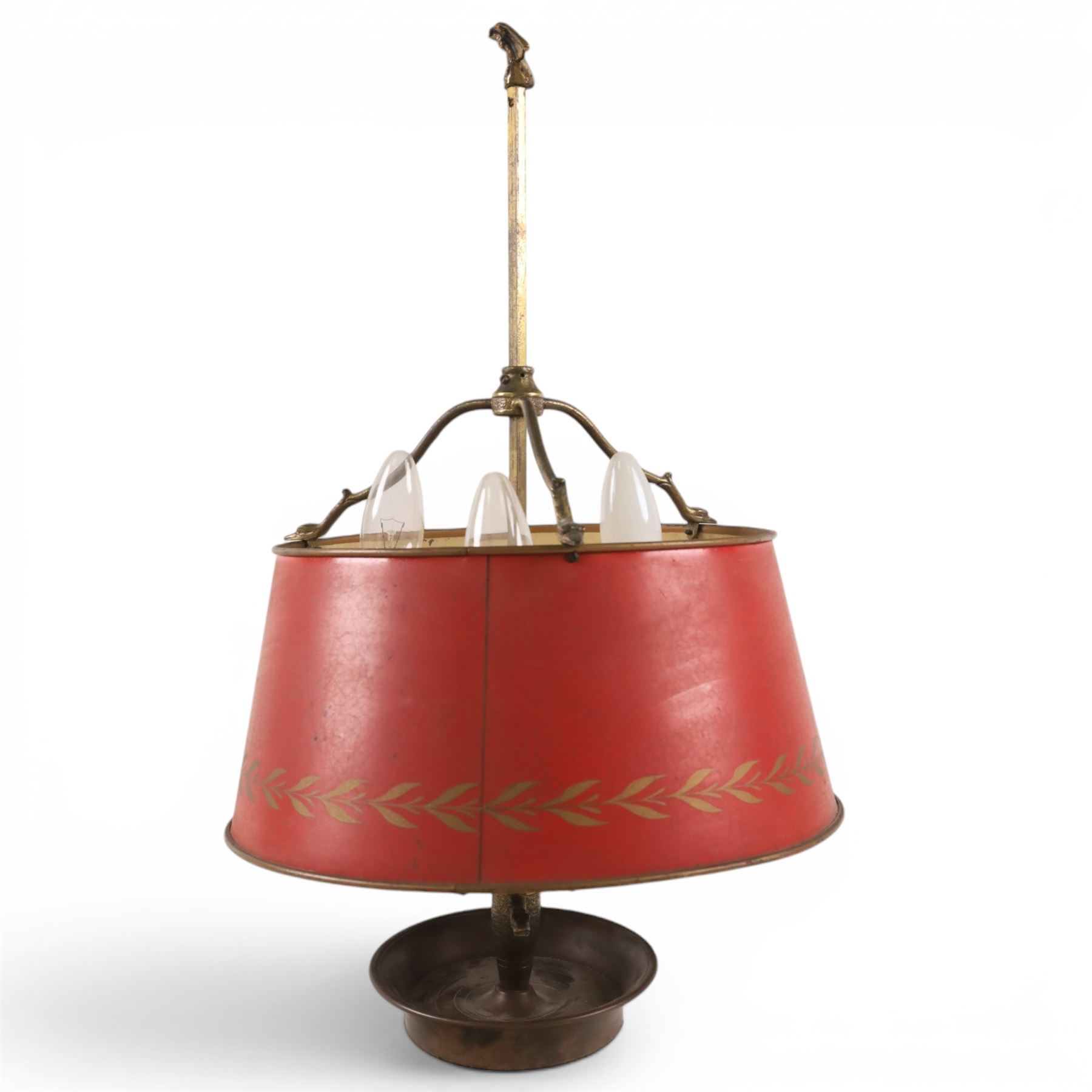 Bouillotte lamp, the adjustable red tole shade above three brass sconces upon a circular dished base, H54cm