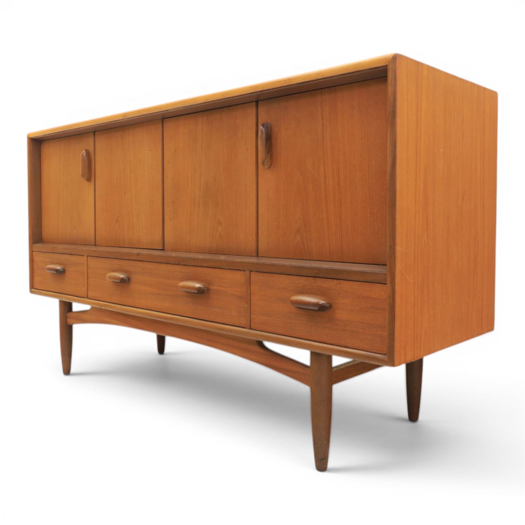 G-Plan - 'Brasilia' teak sideboard, with rectangular top above two concertina doors, above four drawers raised on cylindrical supports