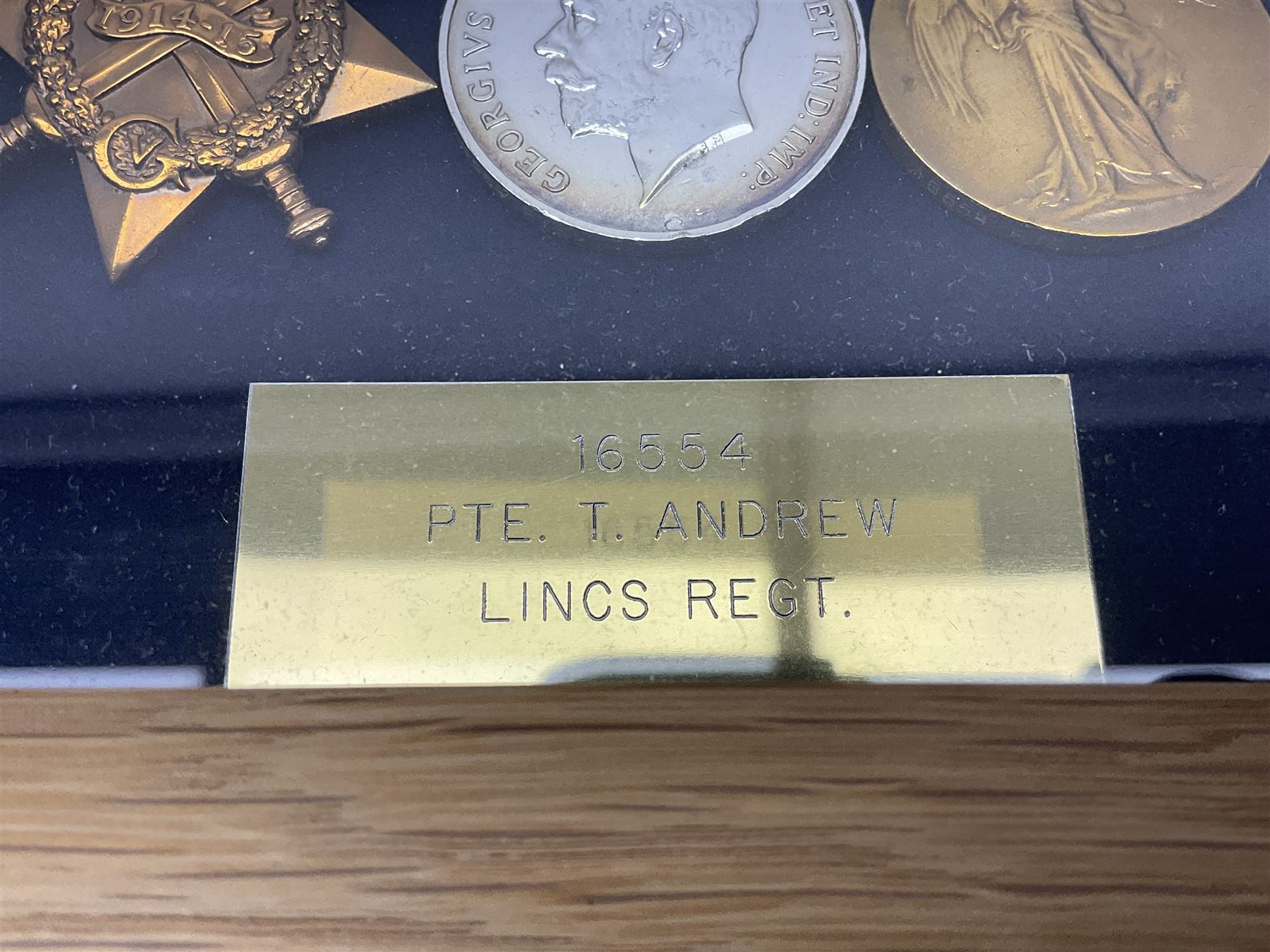 WWI group of three medals with bronze memorial plaque comprising 1914-15 Star, British War Medal and Victory Medal awarded to 16554 Pte. T. Andrew Linc. R. who died on 26th July 1916 whilst travelling to Vimy Ridge, polished and mounted for display in a frame; together with small archive of research material and two WWII V.E. Day Presentation Certificates from the people of Holbeach in Lincolnshire