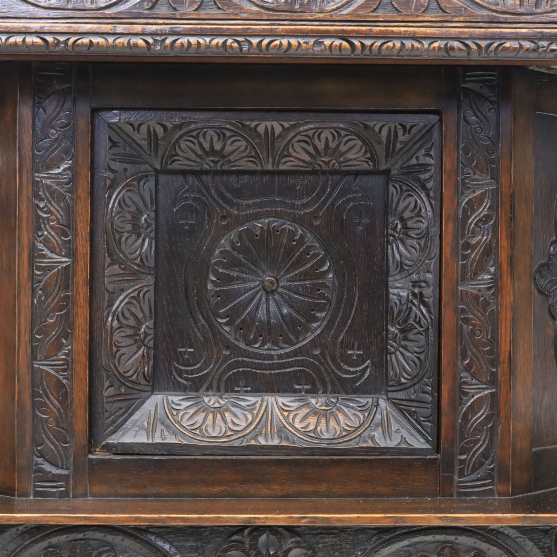 Jacobean revival oak side cabinet, rectangular top above carved frieze of stylised foliage and lunettes, fitted with a central cupboard doors with applied carved panels, above a frieze drawer, supported on turned and carved vase-shaped supports, united by stretcher tier and lower shelf