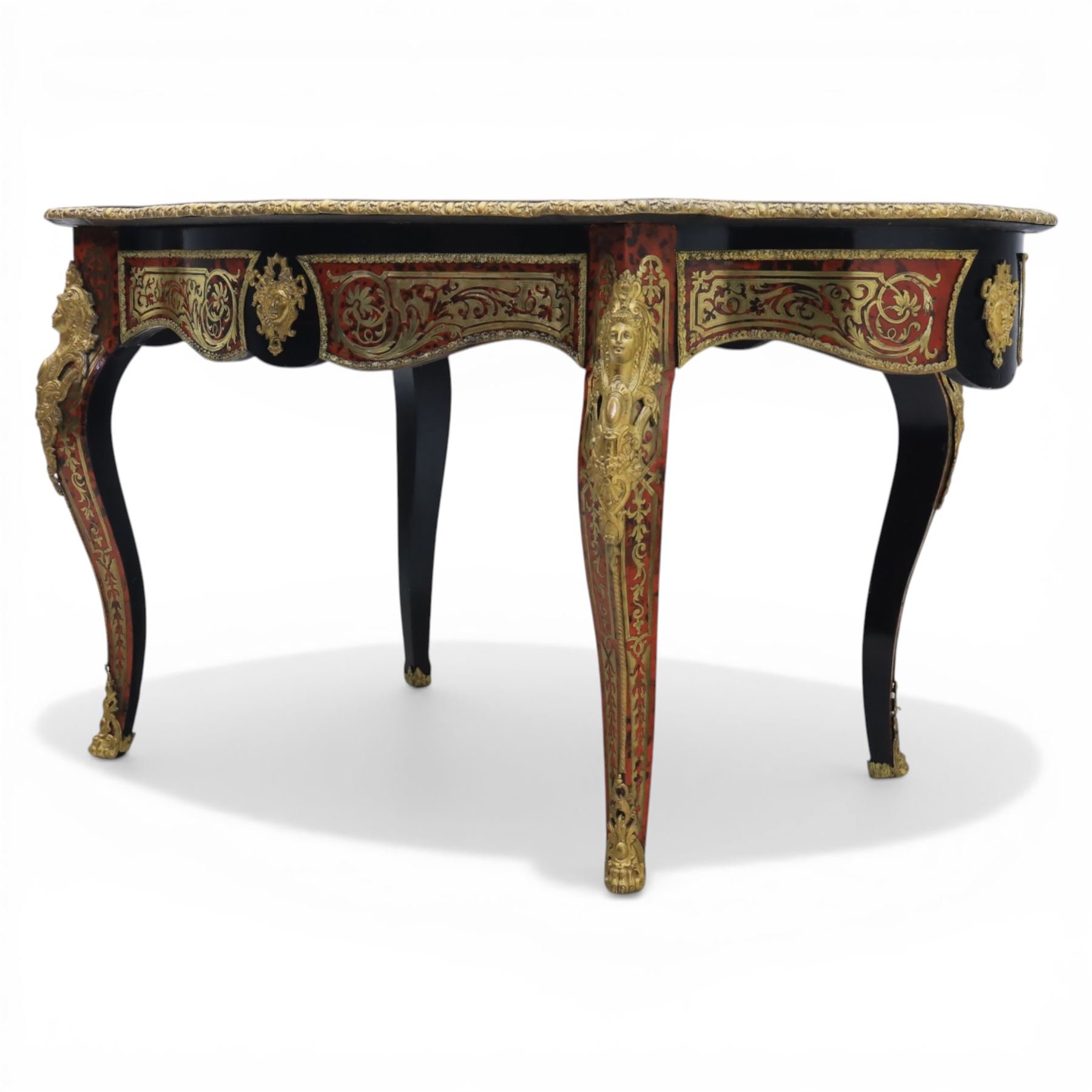 Late 19th century boulle work centre table, shaped serpentine top decorated with brass inlay on red tortoiseshell ground within ebonised border, fitted with single frieze drawer, on cabriole supports with gilt metal mounts and mask terminals