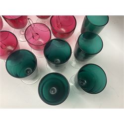 Collection of 19th century coloured glasses, to include nine cranberry glass punch cups, each with clear glass handle and foot and a set of six green glasses, with short clear stems, tallest H10cm