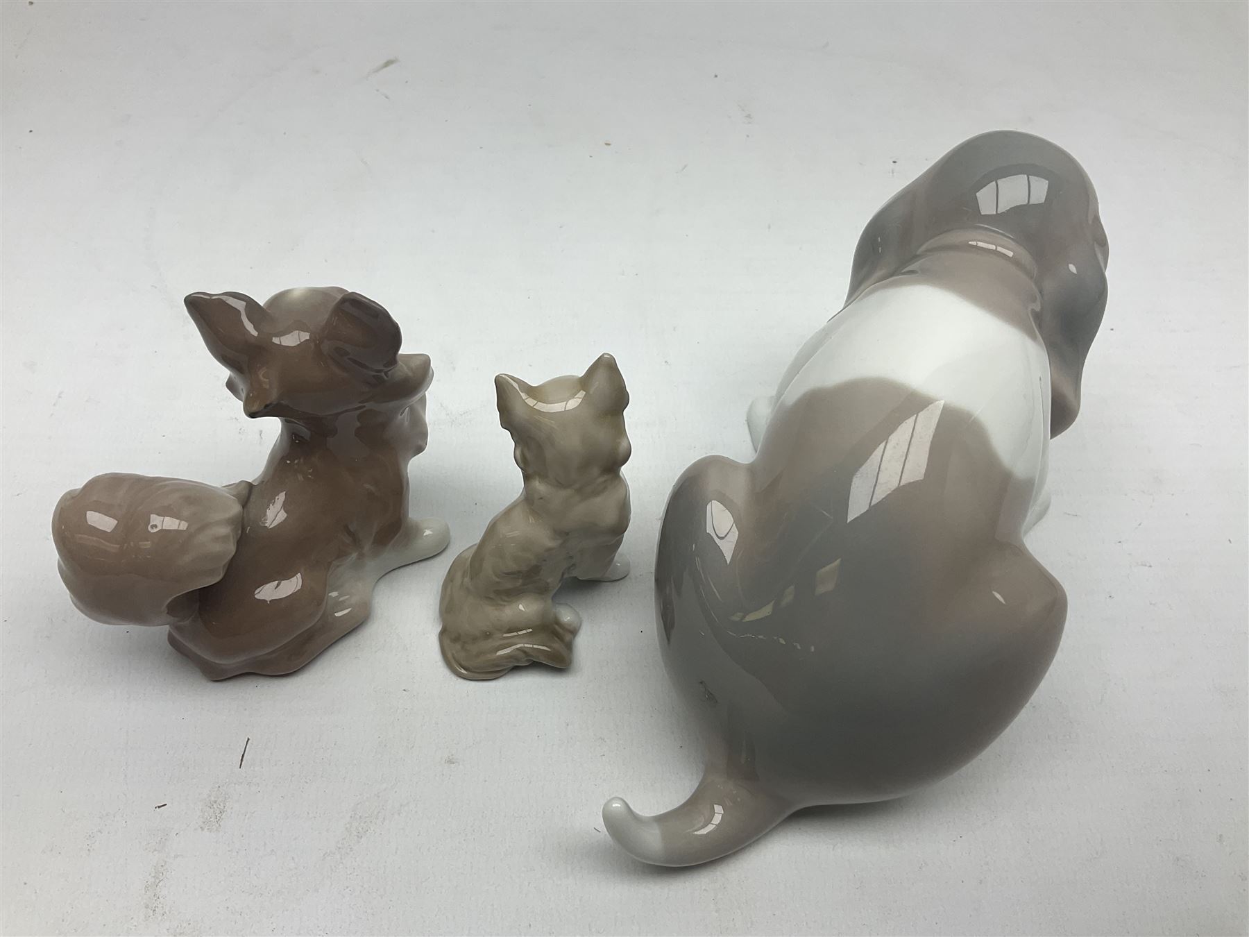 Lladro figures of animals, comprising Mini Lion no 5436, Beautiful Burro no 5683, Hawk Owl no 5422, Beagle Puppy Sitting no 1071, Duck Flying no 1264, Miniature Cat no 5308 and Small Papillon Dog no 4749, four with original boxes, largest example H14cm