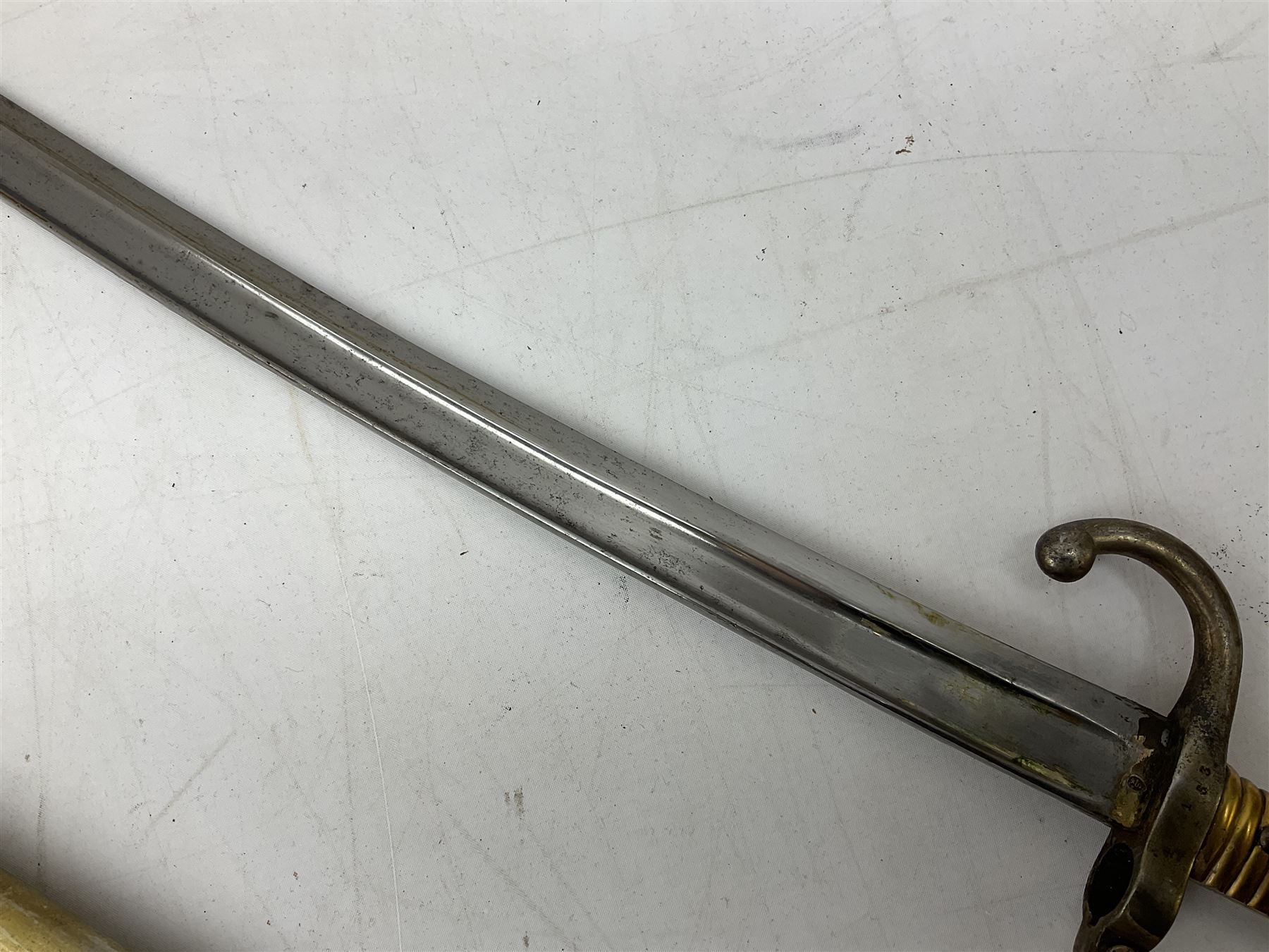 French Model 1866 sabre bayonet with 57cm fullered steel curving blade; in steel scabbard L71cm overall; another Model 1866 sabre bayonet lacking scabbard; and British Pattern 1856 sword bayonet (no scabbard) (3)