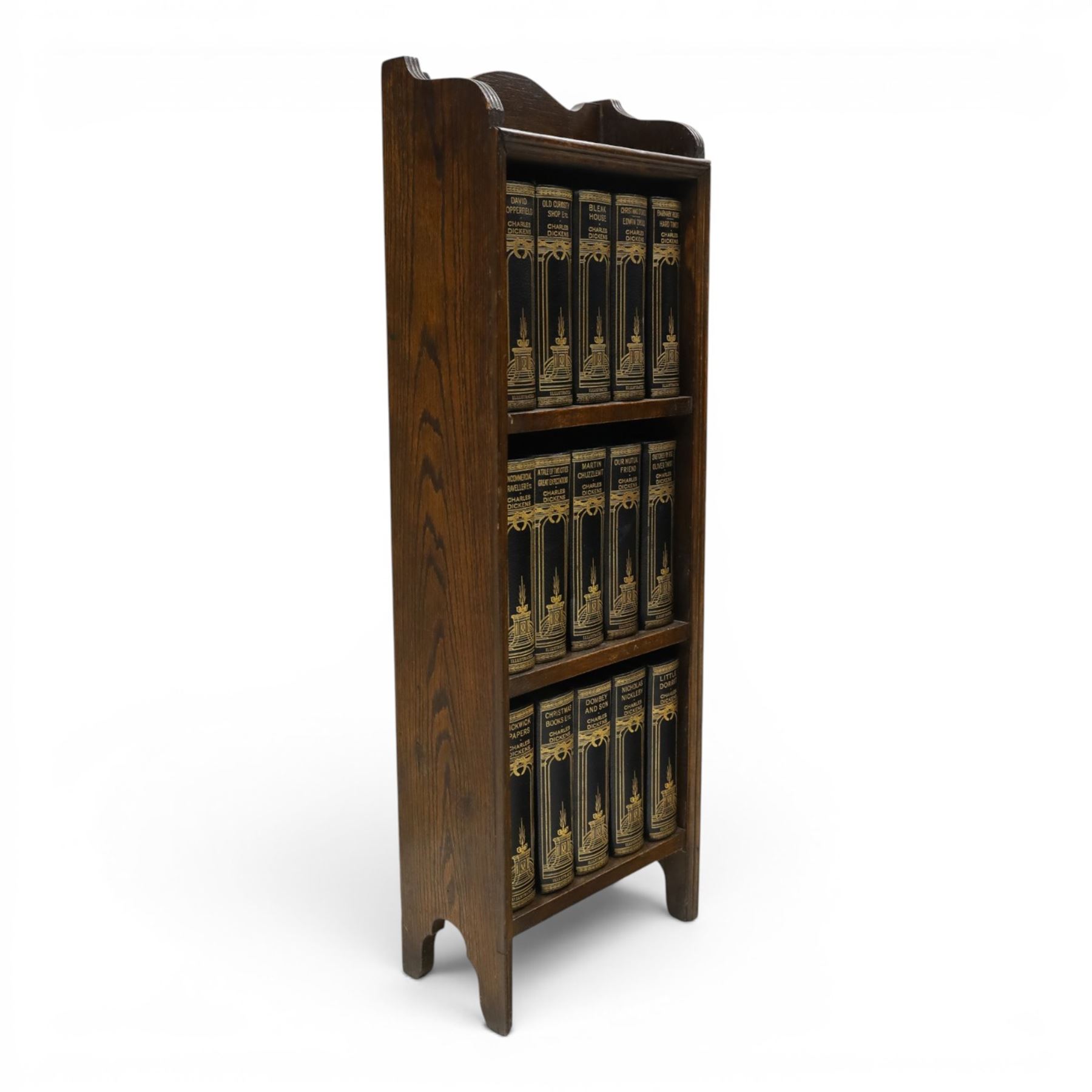 Small Edwardian mahogany open bookcase with Charles Dickens books, oak bookcase with galleried top, containing fifteen hardback books  