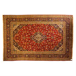Central Persian Kashan hand-knotted carpet, central field in a ruby red ground with an ind...