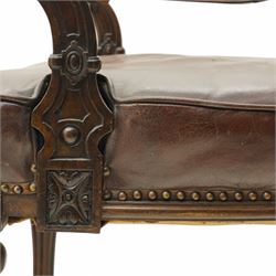 Victorian mahogany library elbow chair, arched cresting rail over shaped and pierced splat carved with cartouche, upholstered arms and seat in brown leather with studded bands, turned and lobe carved front supports on brass and ceramic castors 