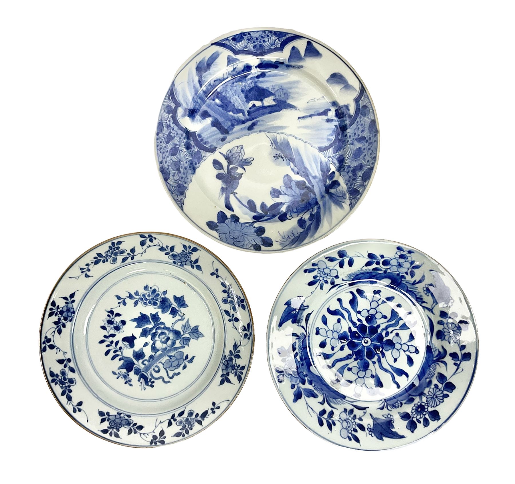 Japanese Meiji period Arita blue and white plate, of circular form, painted with riverside landscape and bird upon flowering branch, with character mark beneath, D24.5cm, together with two 18th century Chinese blue and white plates, each painted with floral design, each approximately D22.5cm