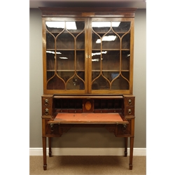 19th century mahogany secretaire bookcase, projecting cornice with figured and satinwood inlaid frieze above two astragal glazed doors, the tambour roll top base with inset leather interior and with drawers, square tapering supports with pierced corner brackets and spade feet, W130cm, H217cm, D48cm