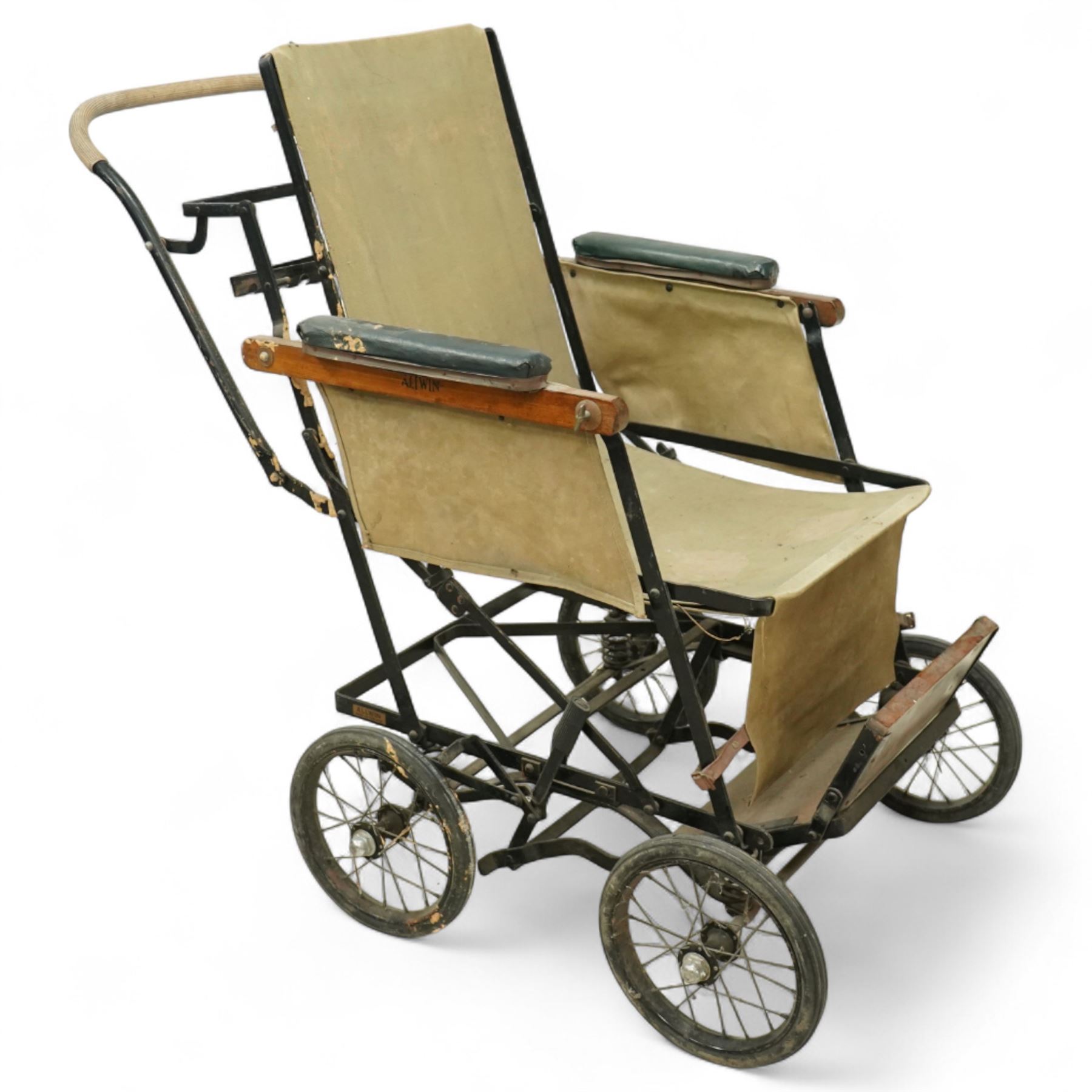 *Early 20th century invalid chair, the tubular metal frame with folding mechanism, canvas seat and back, padded armrests, raised on coil springs and large spoked wheels with wooden footrestFrom the Kirkham Hall Attic & Cellar Collection, sold without reserve