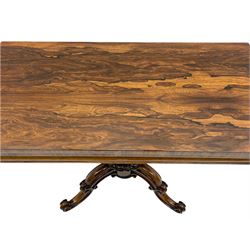 Victorian figured rosewood card table, fold-over swivel top with circular baize lining, moulded frieze with stylised flower head carving to corners, turned column with egg and dart decoration, on quadruple splayed c-scroll carved supports, with brass castors