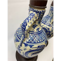 A pair of 20th century blue and white delft water jugs, the bodies decorated with stylised bands, and one example with a deer and the other with a hare, with later wooden spreading circular feet, and stoppers, overall H45cm. 
