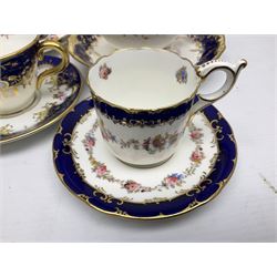 Coalport cobalt blue tea wares, finely decorated in gilt and enamel with foliate motifs and floral sprays throughout, to include coffee cup and saucer in pattern no 5772, decorated with baskets of flowers within ornate gilt reserves, retailed by T. Goode & Co, South Audley St, London, teacup trio no 7771 retailed by William Whiteley London, twin handled cake plate no 5879, teacup and saucer no 8978, cup and saucer no 6546, larger plate no 5225 etc, with various factory stamps and printed marks, together with unmarked teacup and plate similarly decorated with floral sprays within cream and blue borders, largest D22cm (16)