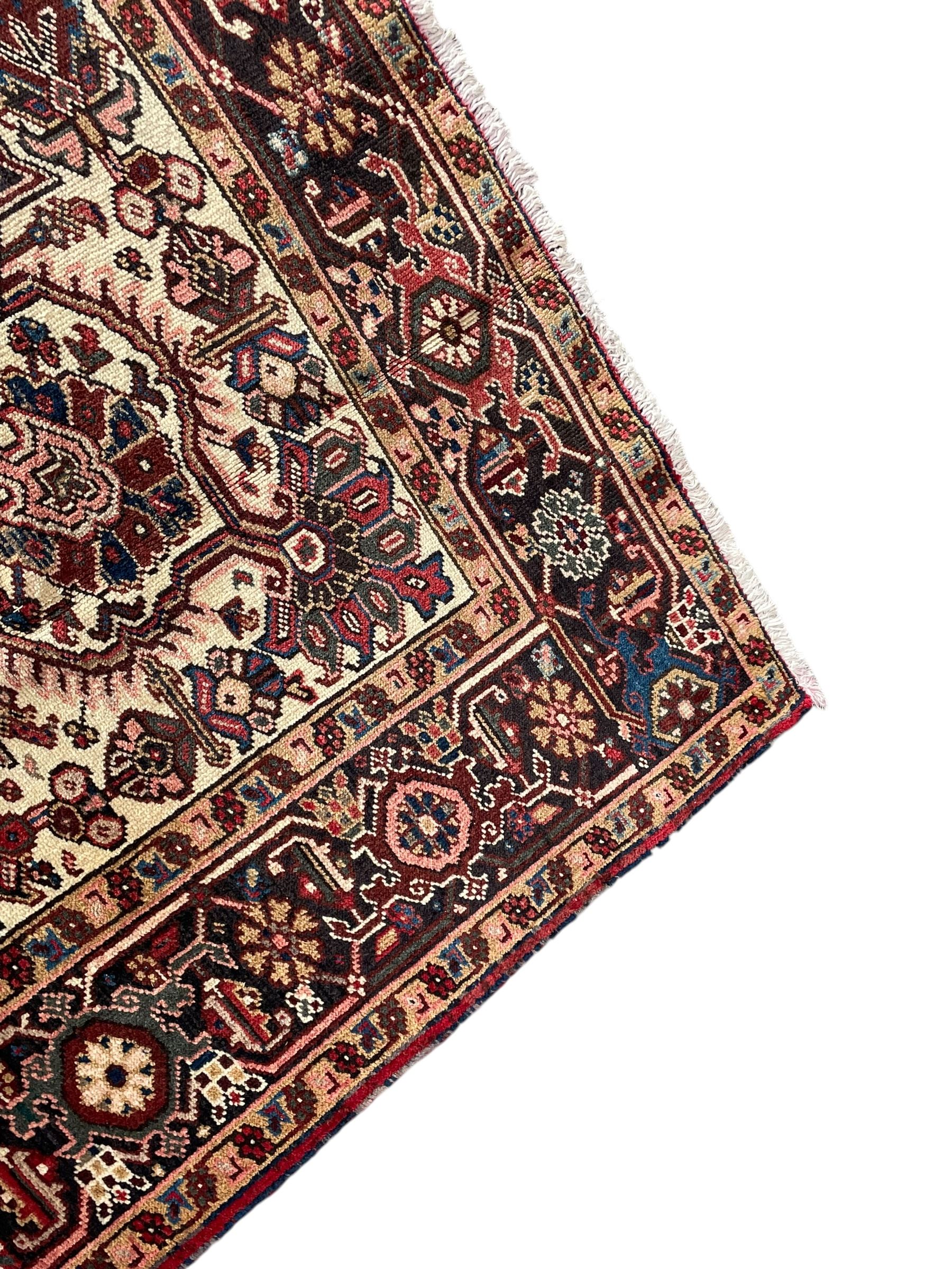 Persian Heriz red ground rug, large medallion decorated with palmettes and Ejder motifs, the border decorated with stylised plant motifs, within floral design guard stripes 