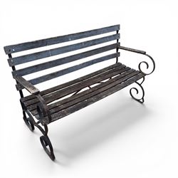 19th century wrought iron strapwork and slatted wood garden bench, the arm terminals and end supports of scrolling form