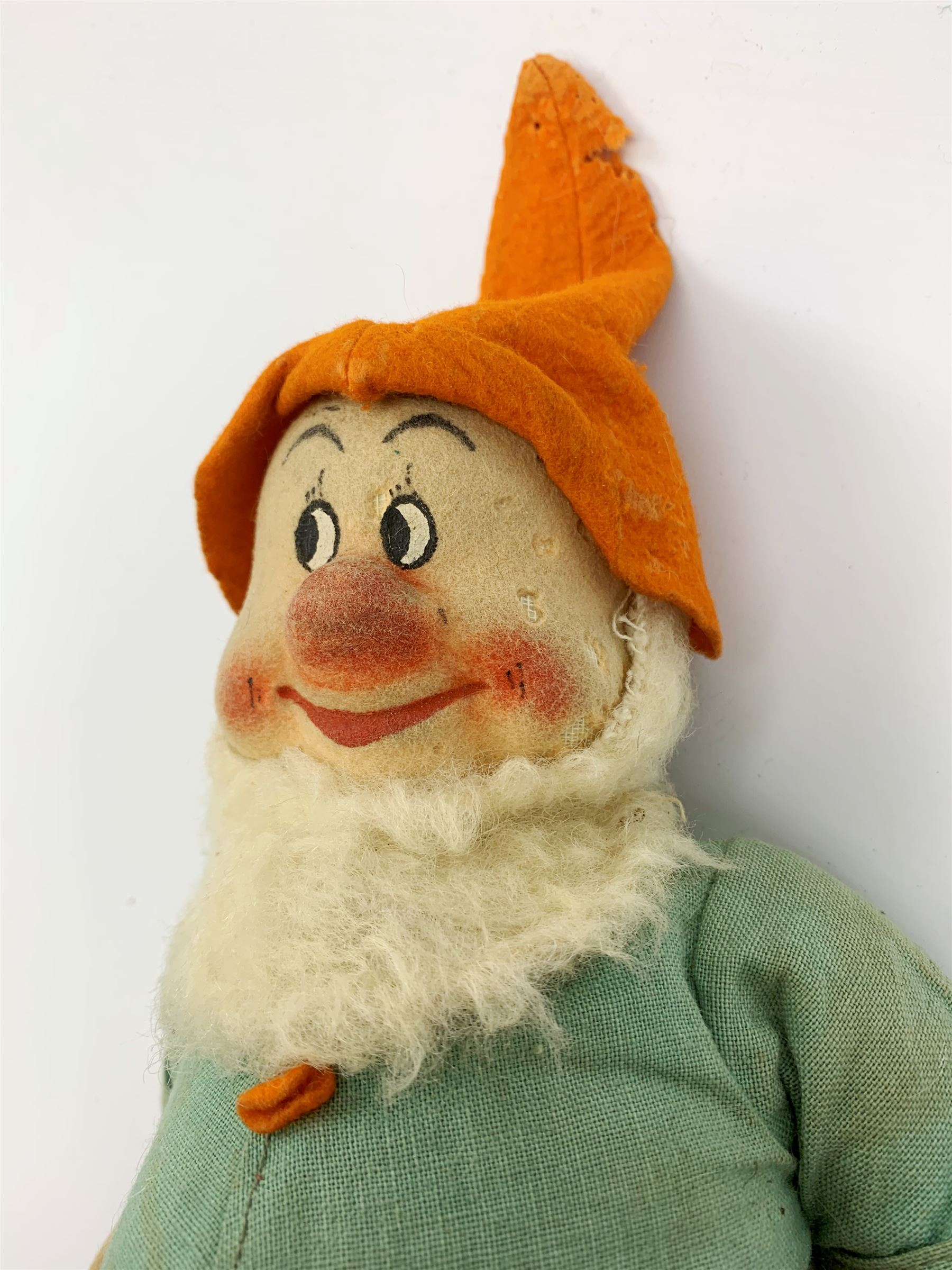 Chad Valley pressed felt figure of the Disney Snow White dwarf 'Doc' with painted facial features, standing wearing a green linen suit with orange hat, belt, buttons and shoes H13