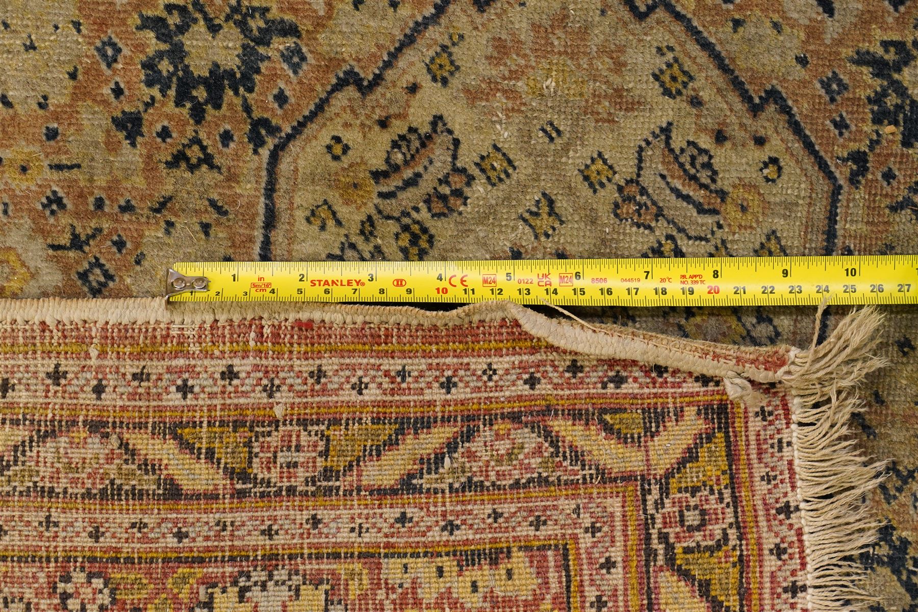 Two hand-knotted rugs, comprising Persian medallion rug and tribal rug, Persian hand-knotted rug, ivory ground centred by shaped floral medallion with pendants, surrounded by stylised flowerheads and foliate motifs, enclosed by multiple floral and geometric borders, H155cm, W123cm; tribal hand-knotted rug, dark brown ground with repeating linked geometric diamond medallions in orange and green, enclosed by ivory geometric border, striped ends with fringes, H150cm, W71cm
