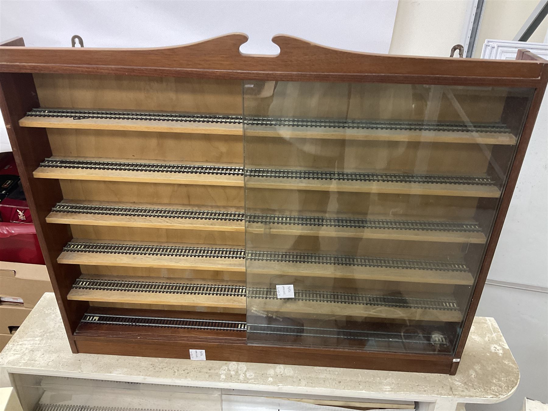 Six shelved cabinets for displaying ‘00’ gauge locomotives comprising plain plywood and white painted examples with track applied to various shelves, largest H63cm, W107cm, D27cm; Collection of tools for building model locomotives to include Weller PU-2D Soldering Pencil and Standard Tip Soldering Iron 20W/230V, Humbrol Modellers Airbrush, Power Supply Units and two wooden chests one of which housing a collection of tools including tweezers, scalping tools, wrenches etc 