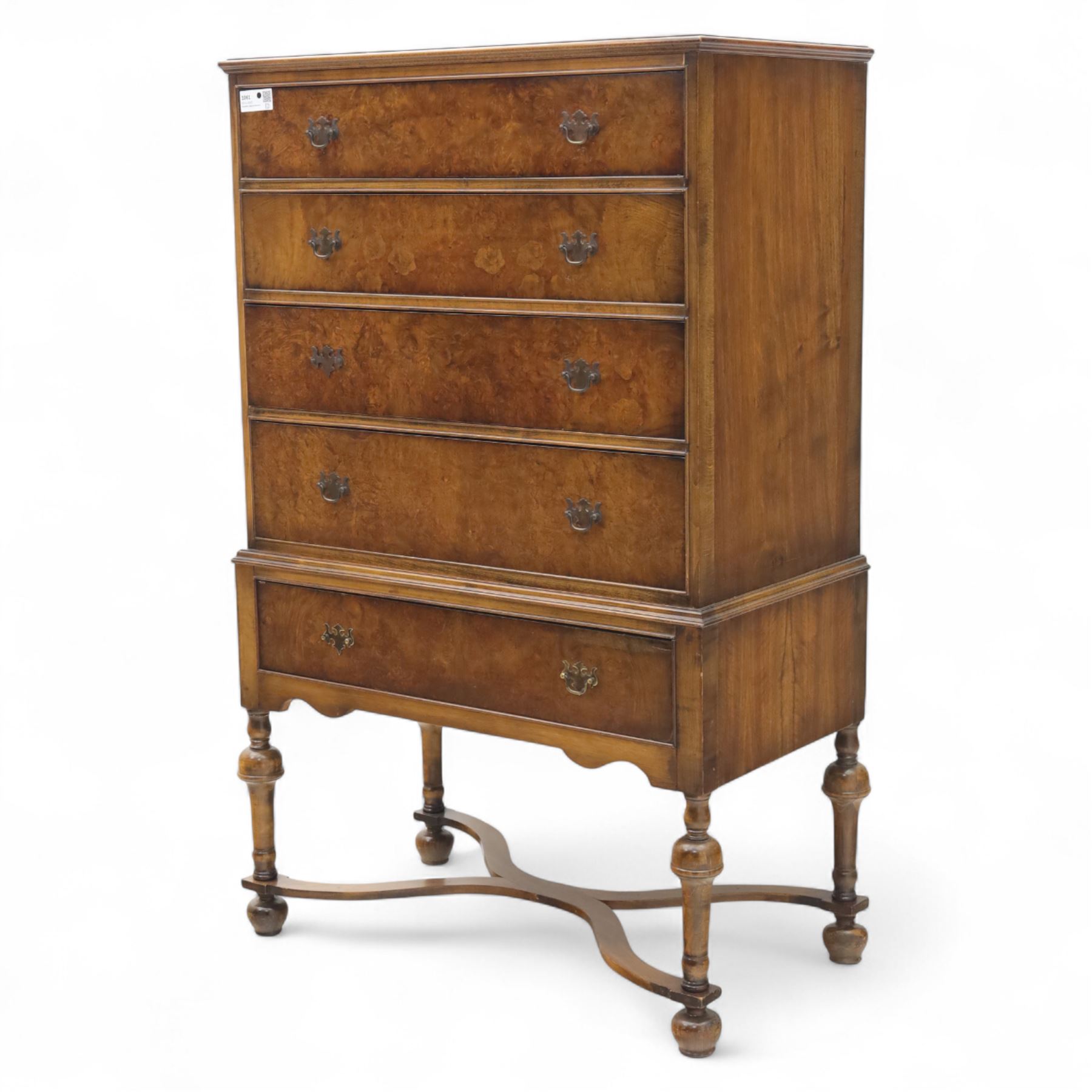 Georgian style walnut chest on stand, the figured top section fitted with four long drawers above a further drawer on the base, brass swan-neck handles, on turned legs joined by shaped stretchers with bun feet