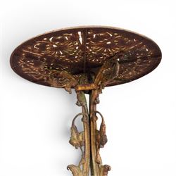 Victorian cast iron garden table, circular pierced top with foliate and scroll decoration, raised on an ornate tripod base with natural weathered paint finish.