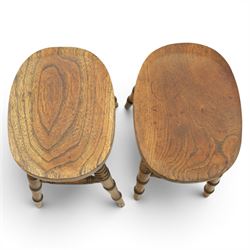Pair of country elm stools, with oval dished seat raised on turned wooden supports, united by a H-stretcher