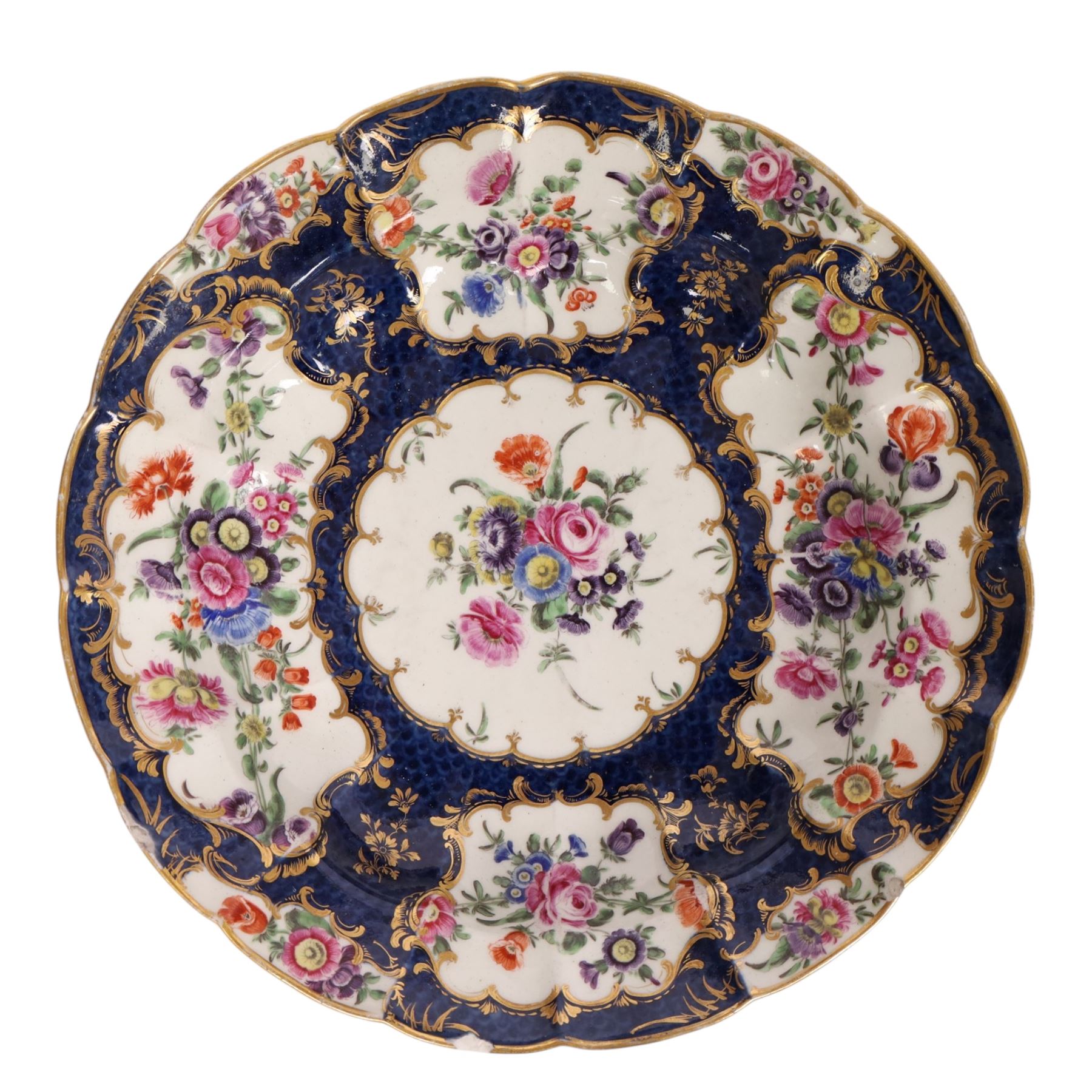 Pair of Worcester junket dishes, c1770, painted with panels of flowers on a blue scale ground within richly gilt rococo style borders and scalloped rim, hatched square mark to base, D24.5cm (2)
Notes: label suggests provenance relating to the Brownlow family of Belton House.