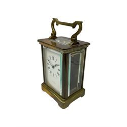 An early 20th century French timepiece carriage clock in a Corniche case with a white enamel dial , Roman numerals, decorative steel hands and minute markers, four bevelled glass panels and a rectangular panel to the top, with a replacement jewelled lever platform escapement with timing screws.