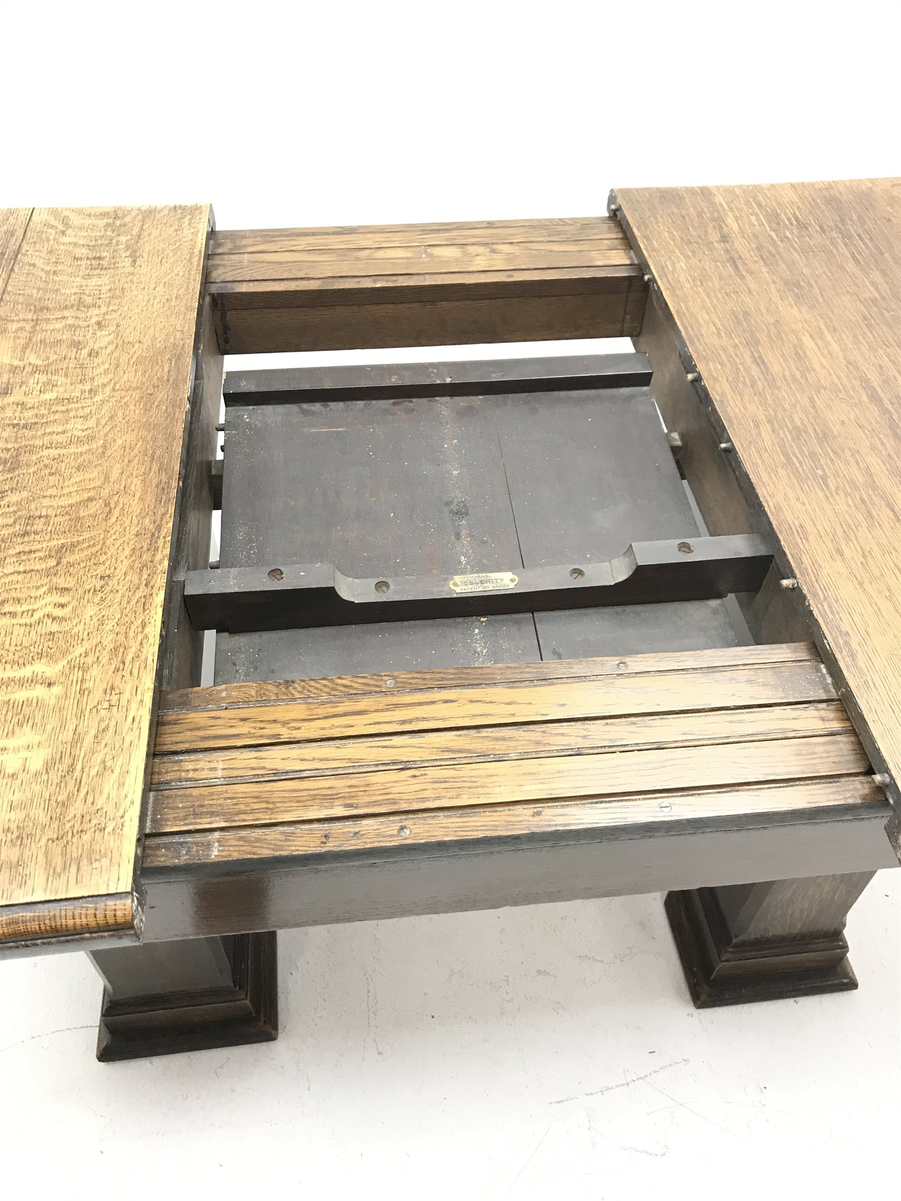 'The Celerity Patent' - Early 20th century oak extending dining table, canted rectangular moulded top with foldout leaf, on two rectangular box supports, 91cm x 122cm - 167cm, H74cm