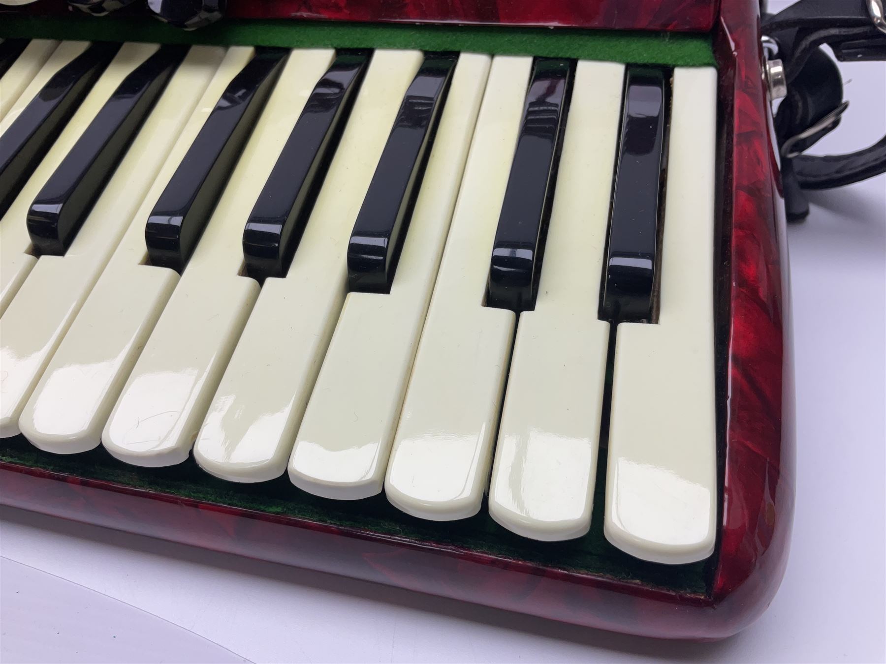 Hsinghai Studio piano accordion with red pearline finish, twenty keys and seventy-two buttons W44cm; in hard carrying case with additional The Music Room soft gig case