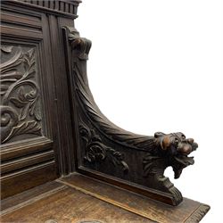 19th century oak hall bench, dentil cresting rail over moulded frame with panelled back carved with fire-breathing mythical beasts and central acanthus leaf motif, scroll carved down-sweeping arms carved with grotesque masks with scrolled foliage and shells, hinged box seat carved with scrolling foliage over panelled front with further carved foliage decoration, on paw carved front feet 