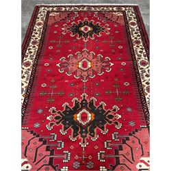 Persian Hamandan rug, the red ground field decorated with triple medallions and stylised motifs