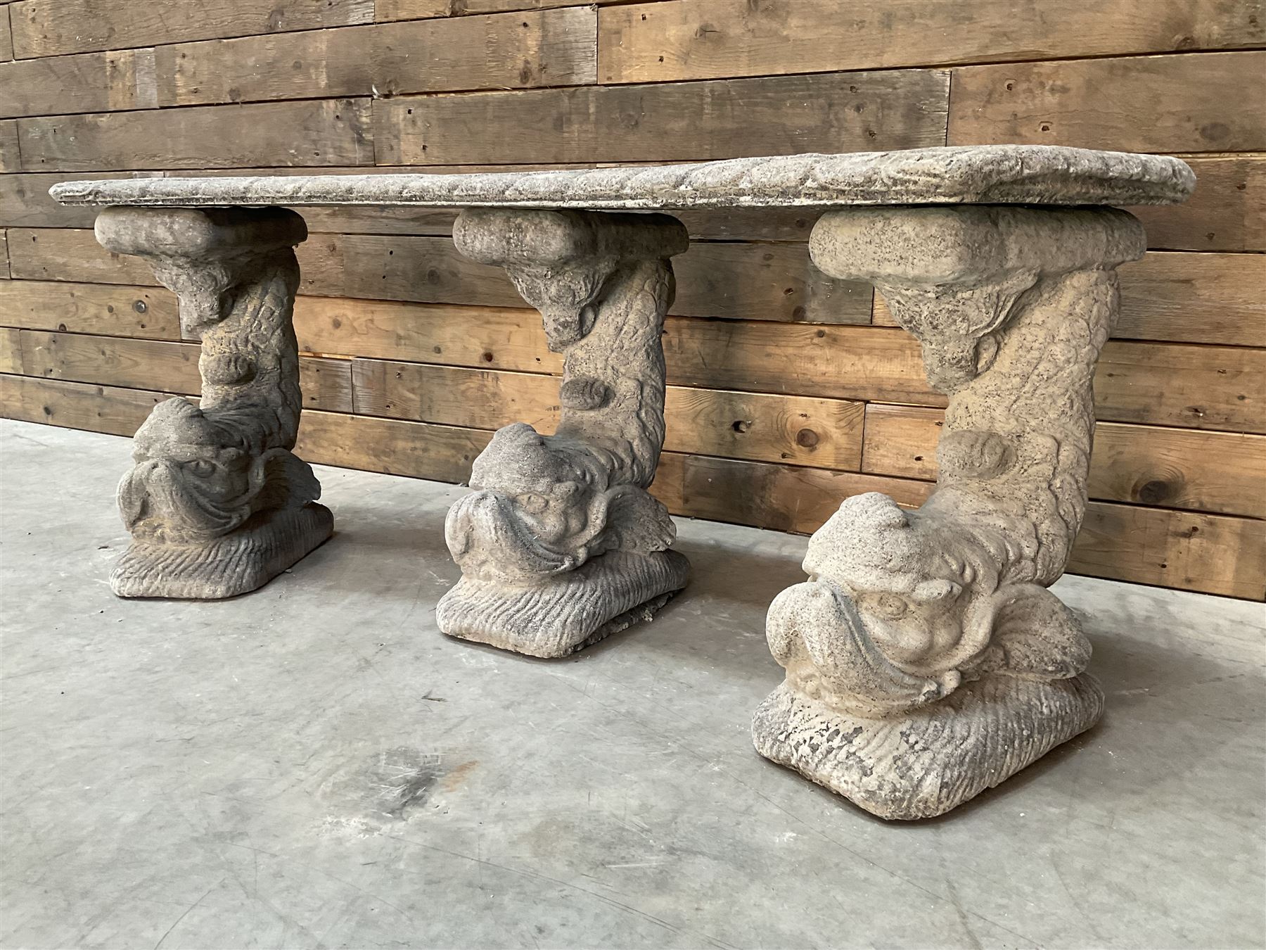Cast stone four piece curved Dolphin bench, set with three dolphin pillars, curved rectangular slab top with detailed border