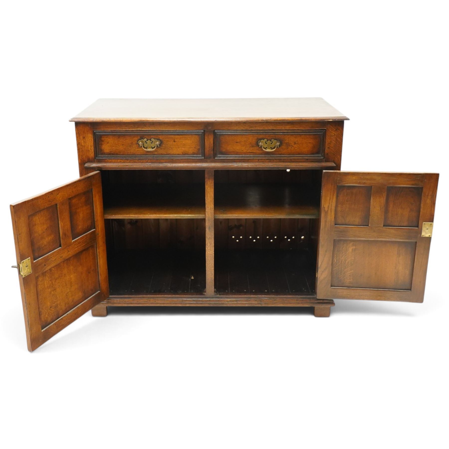 18th century style oak dresser base, rectangular moulded top over two frieze drawers with brass handles, twin panelled cupboard doors below with pierced brass escutcheons, on stile feet