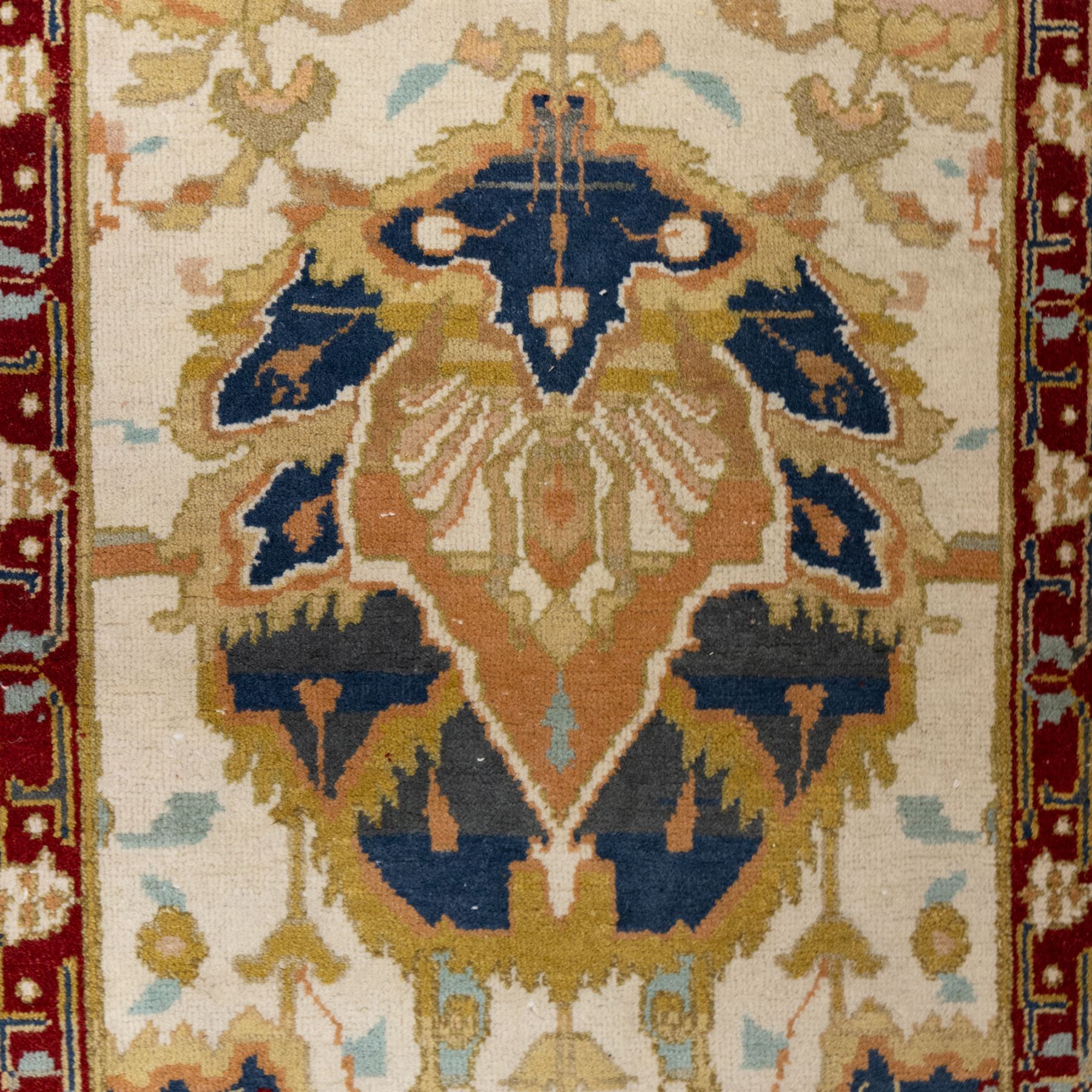 Agra wool runner, cream field decorated with large stylised palmettes, scrolling vines and flowerheads, enclosed by red main border with foliate motifs and fringed ends