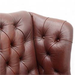 Georgian design leather wingback armchair, deep-buttoned burgundy leather upholstery with rolled arms, studded detail along the edges, raised on cabriole supports terminating in claw and ball feet

