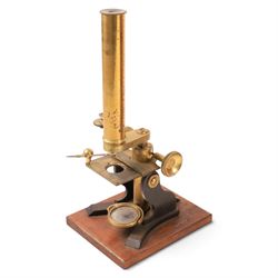 Early 20th century brass microscope, with spare lenses and a small collection of prepared slides, within wooden carry case