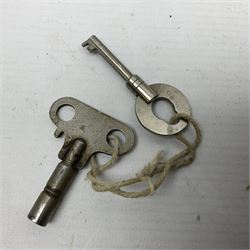 Metal cased drum shaped travelling clock with grey hammered finish, French clockwork movement and stitched leather outer case with shoulder strap; bears manuscript label 'Royal Armament Research and Development Establishment - serial no.09433' D13cm overall