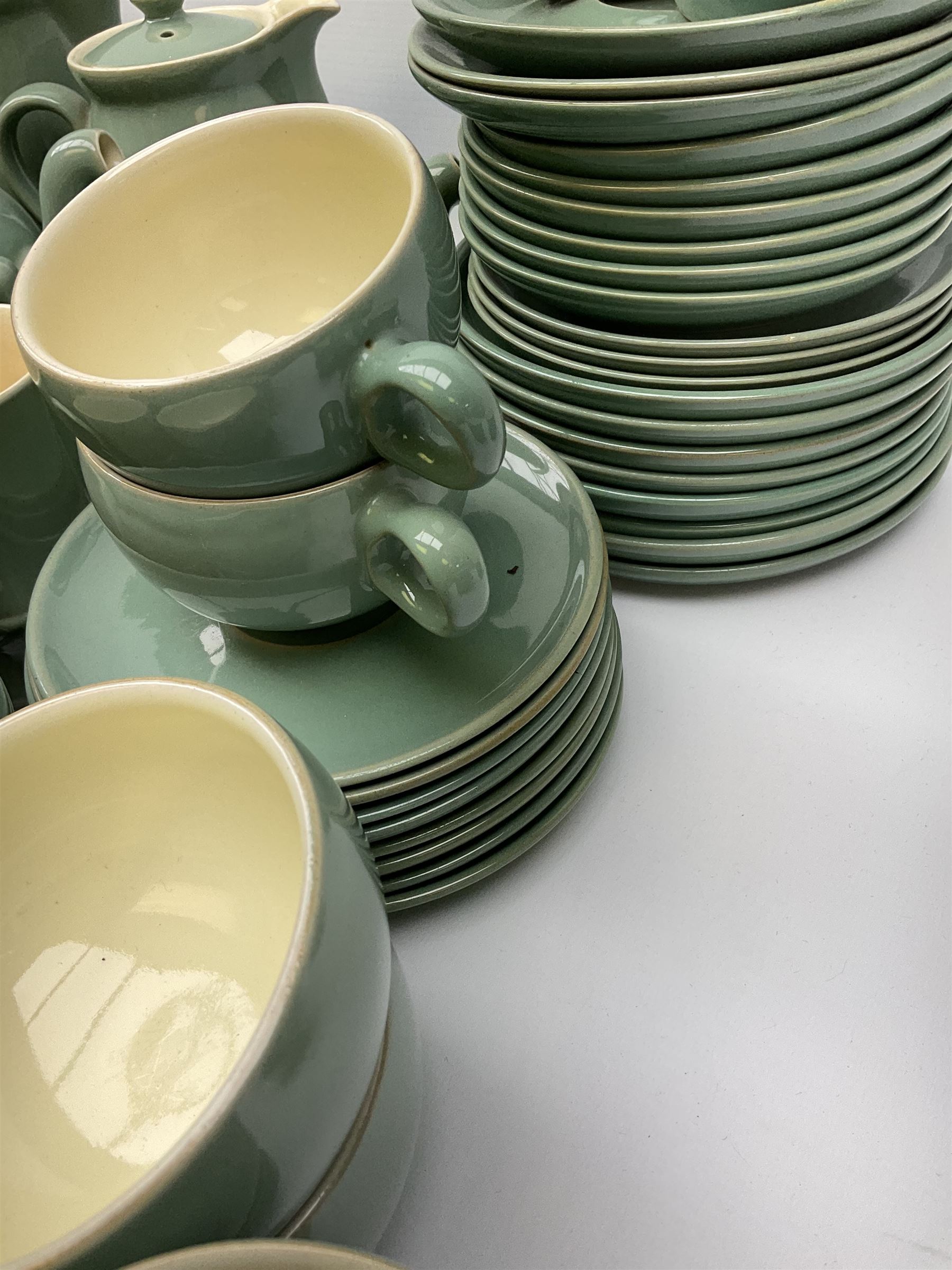 Denby Manor Green pattern tea service, comprising of three teapots, twelve coffee pots of various sizes, four hot water jugs with lids, seven jugs, eleven teacups, four mugs, seventeen saucers, six sugar bowls, two sugar bowls with lids and eleven side plates.  